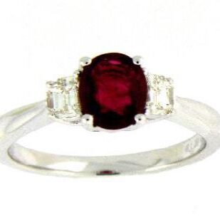 Elegant silver ring with a deep red central gemstone and clear side stones.