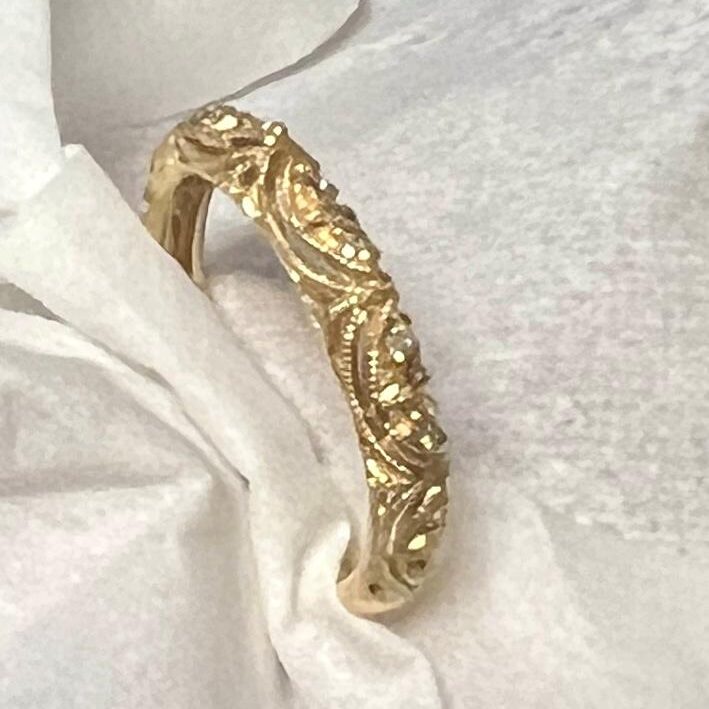 Elegant gold ring with intricate floral engravings.