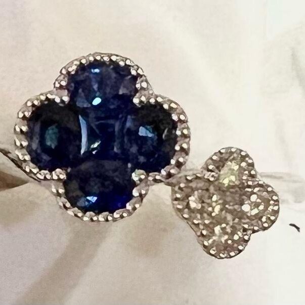 Elegant ring with blue and clear gemstones in floral design.