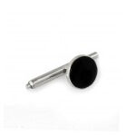A silver cufflink with a black circular face.
