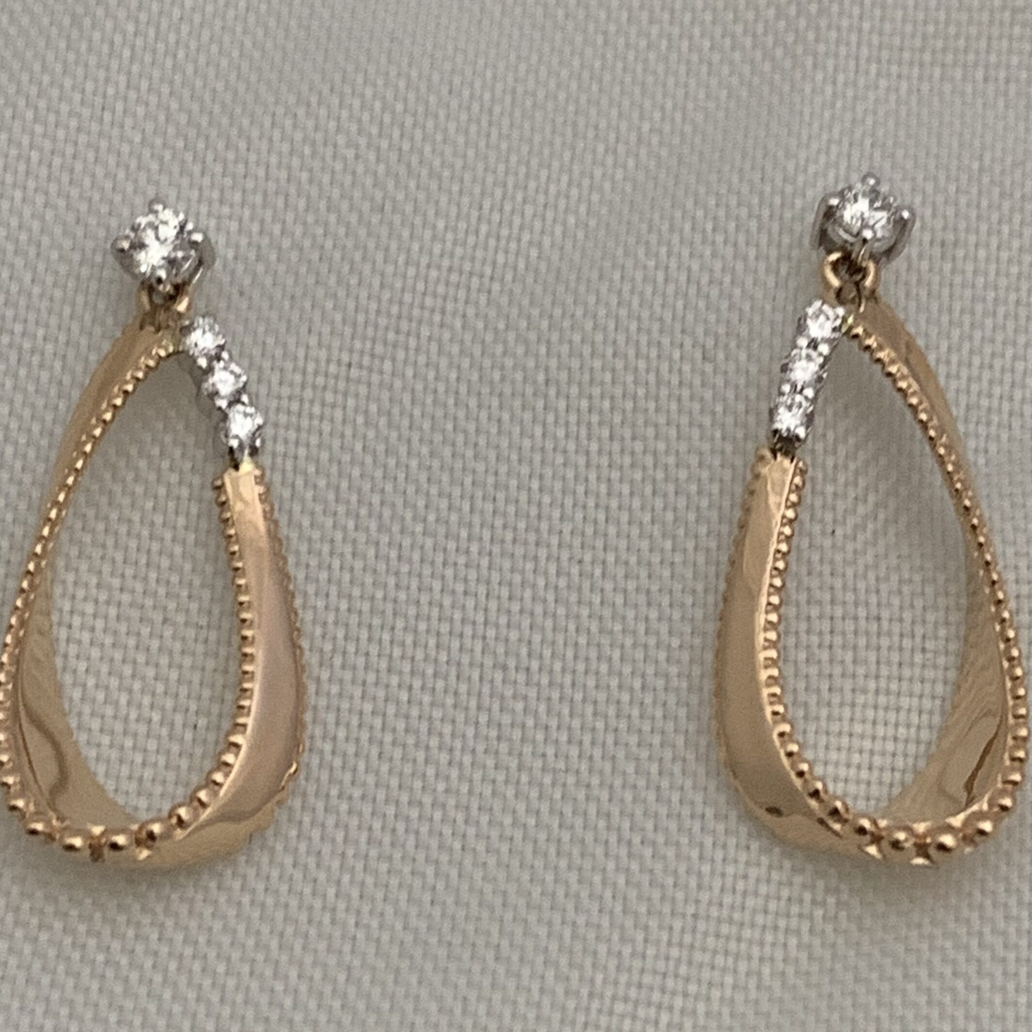 Elegant gold and diamond loop earrings with a textured design.