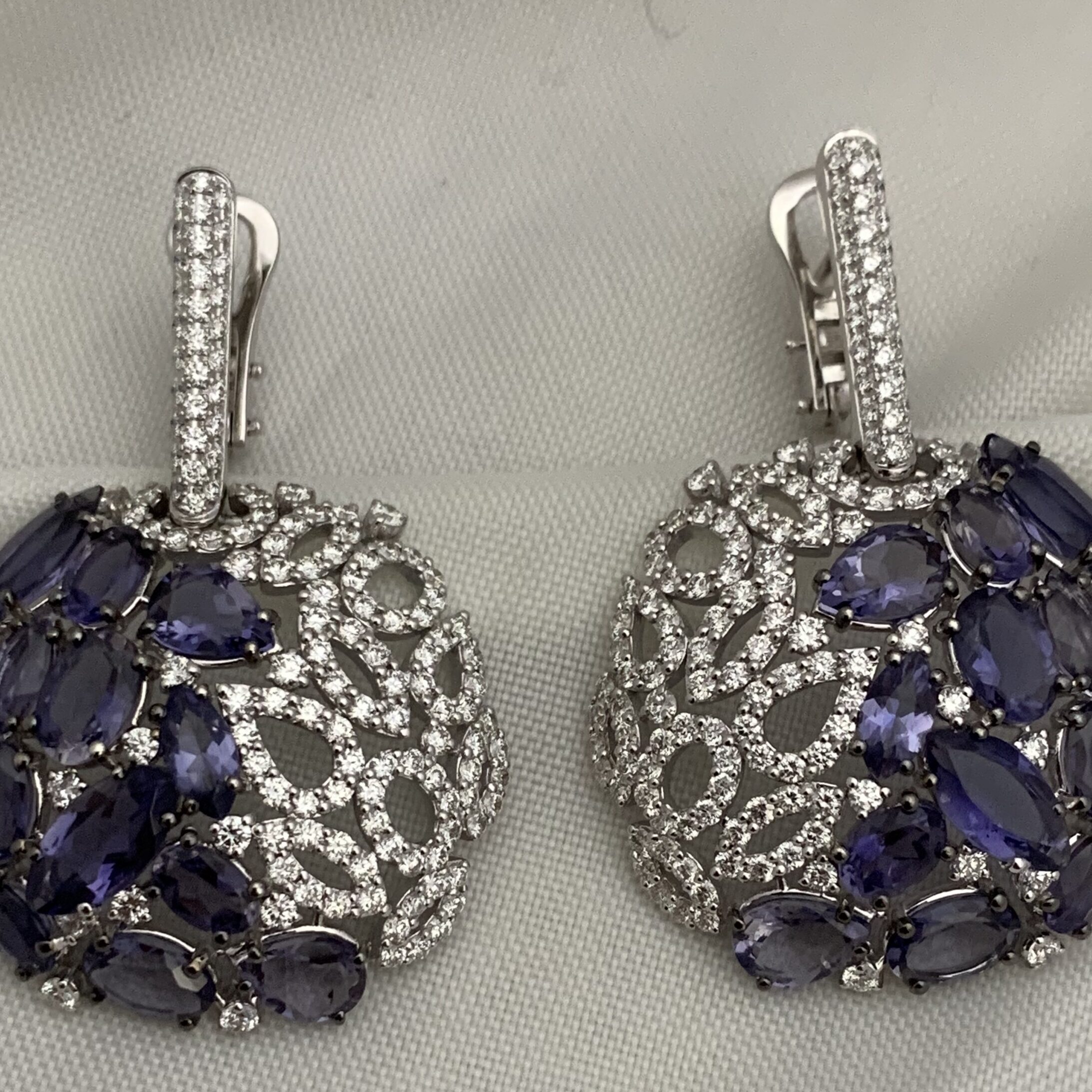 Elegant round earrings with purple stones and intricate silver detailing.