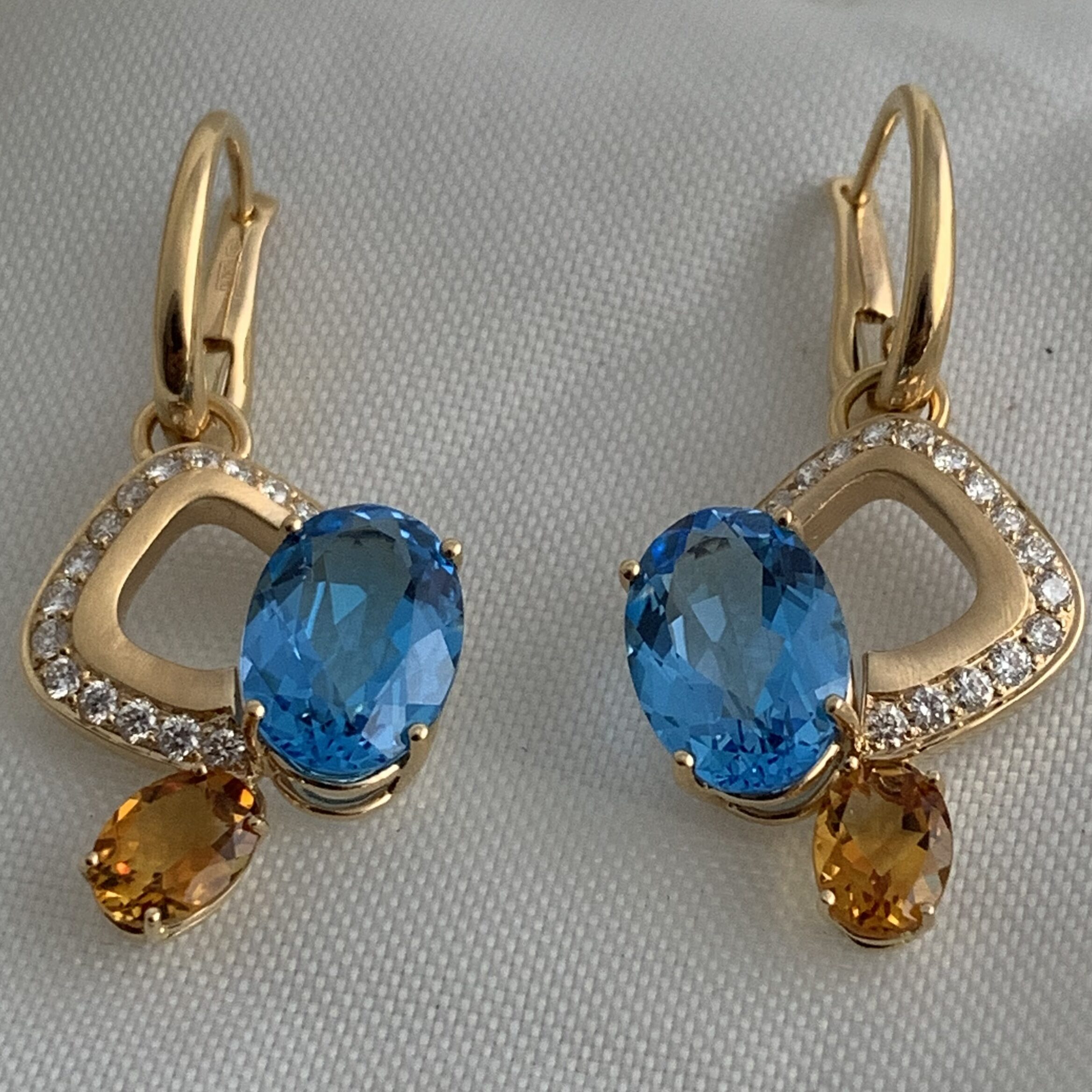 Elegant gold earrings with blue and amber gemstones.