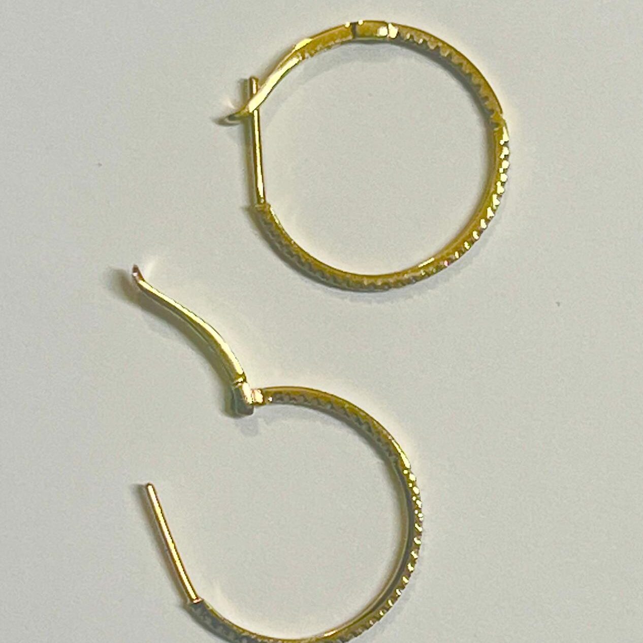 Pair of gold hoop earrings with textured design.