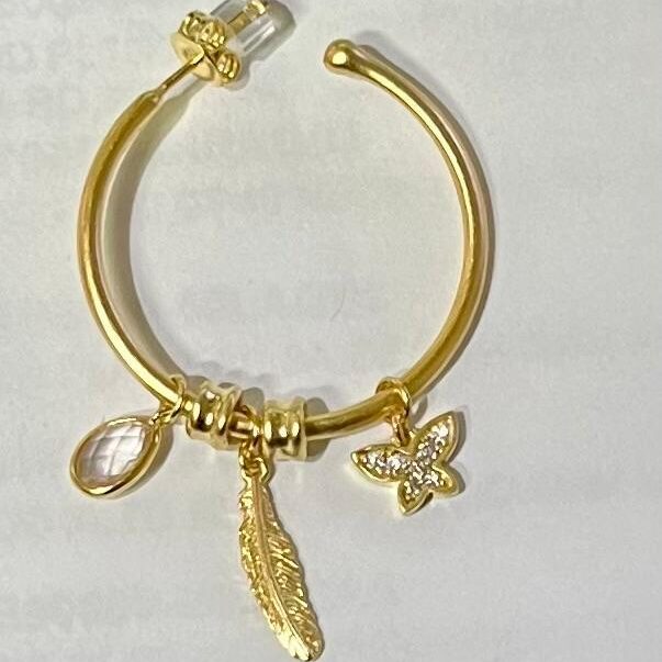 Elegant gold bracelet with charm pendants including a flower, feather, and teardrop.