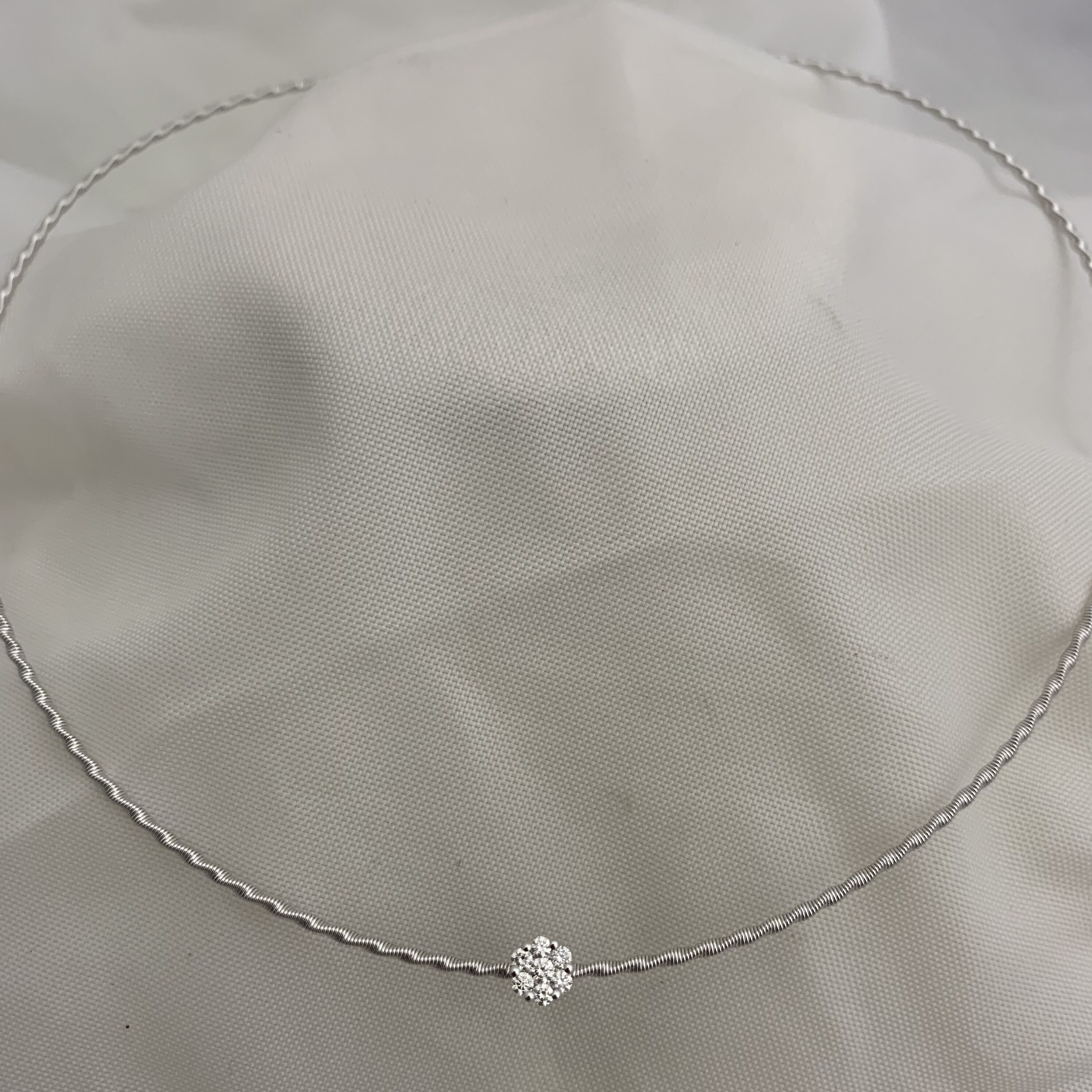 Delicate silver chain necklace with a small flower-shaped pendant.