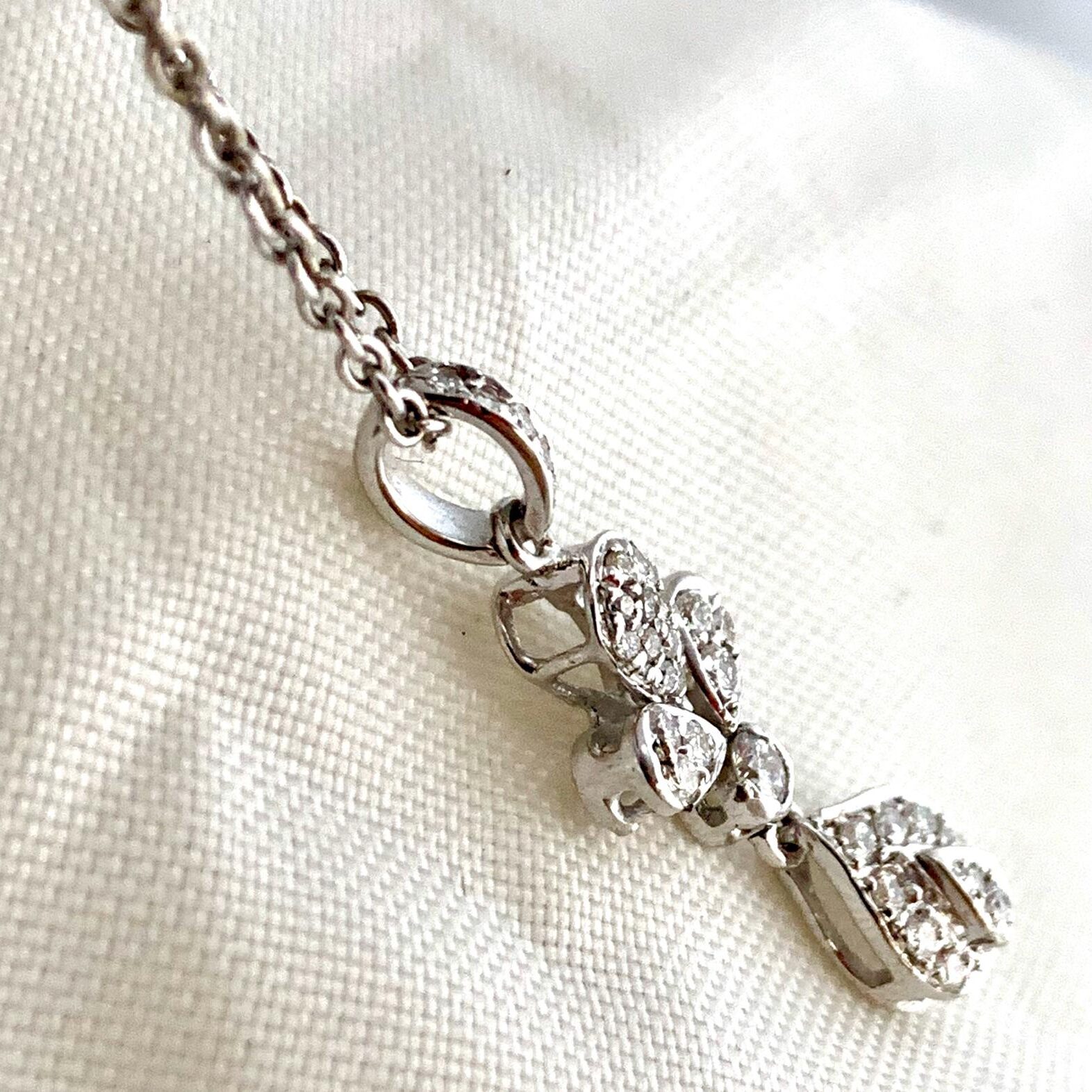 Silver teddy bear pendant necklace with intricate detailing.
