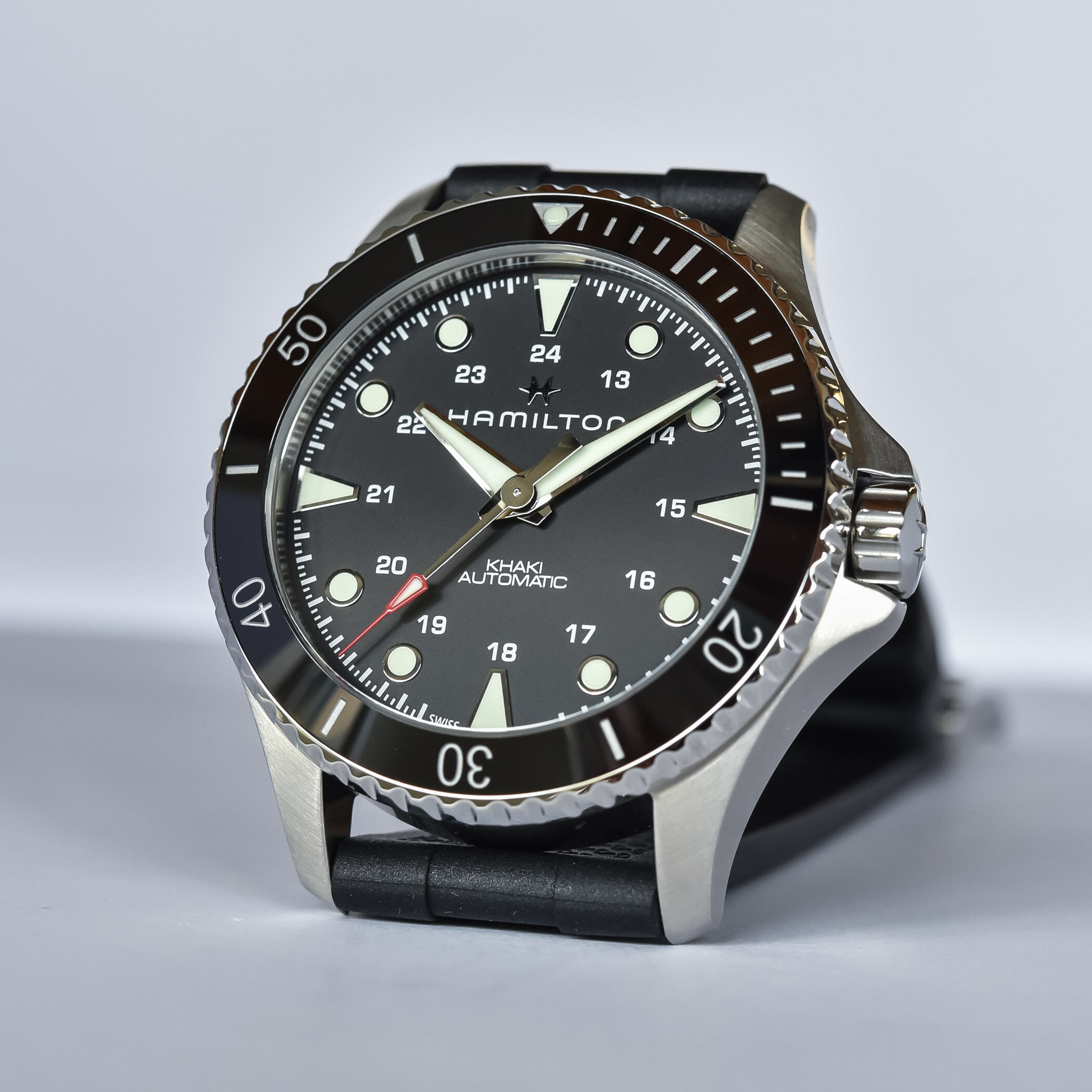 Close-up of a black dive watch with a stainless steel case and rotating bezel.