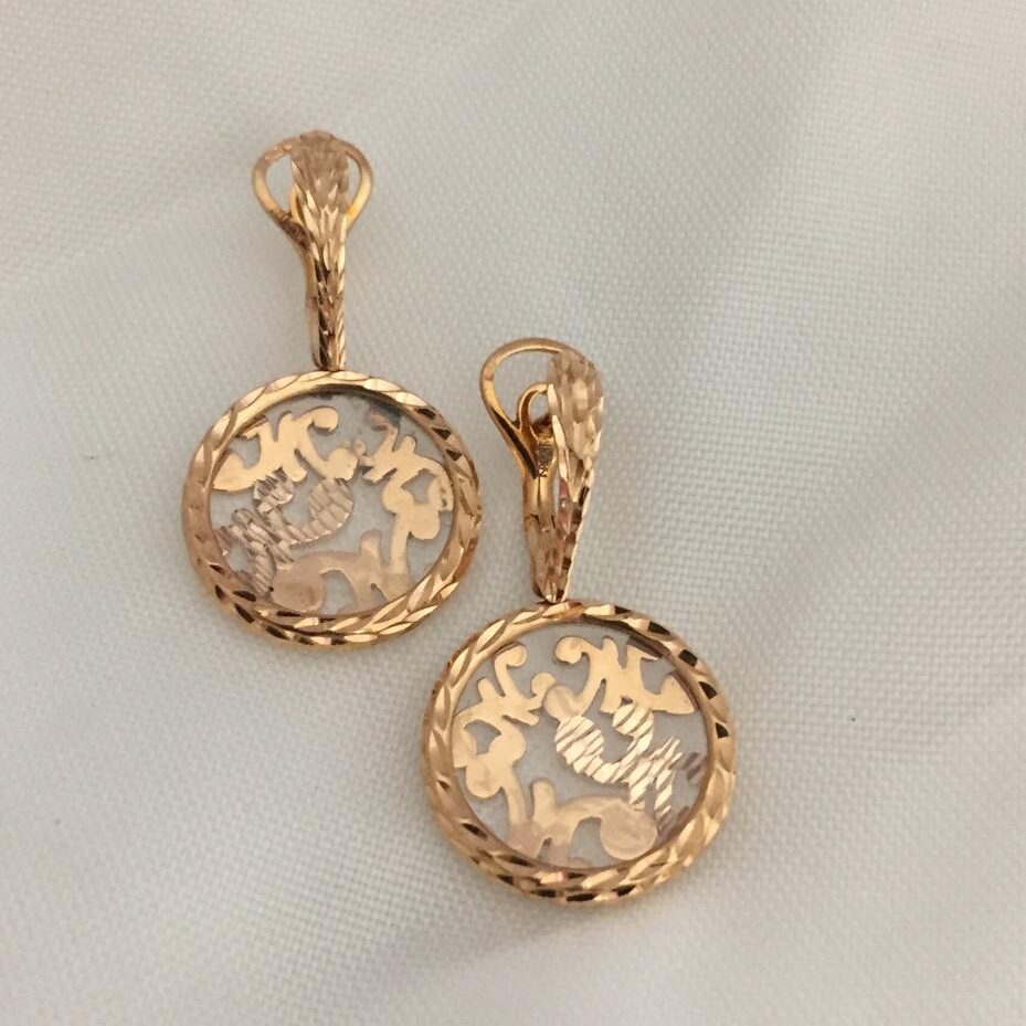 Elegant gold earrings with intricate floral cutout design.