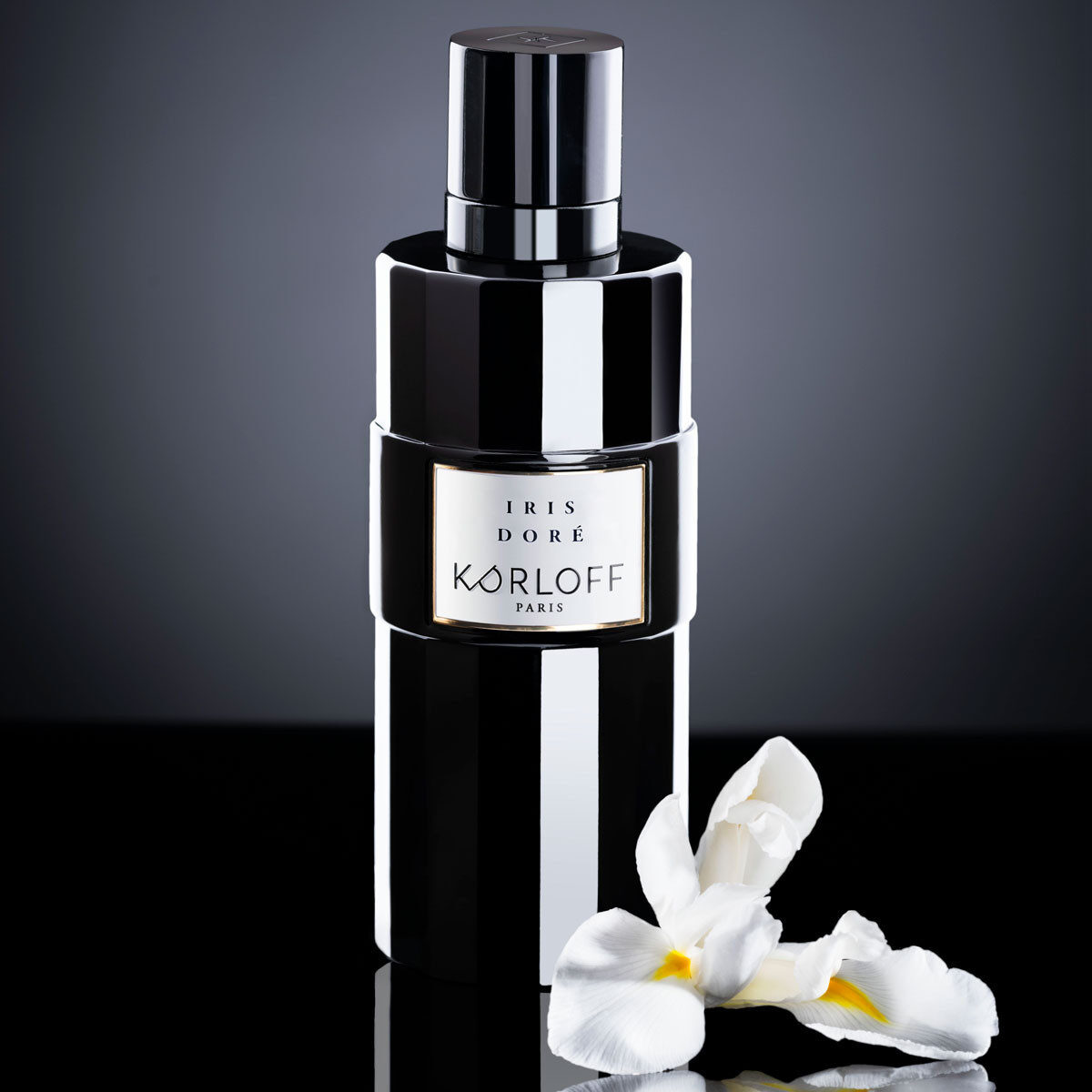 Elegant black perfume bottle with white orchids on a dark background.