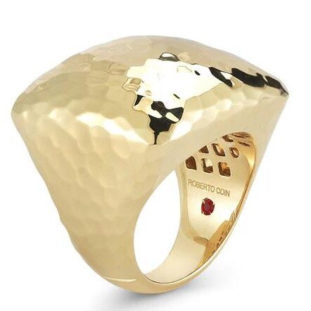 A shiny gold hammered dome ring with a smooth band.